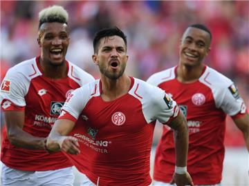 Jean-Philippe Gbamin (l-r), Torschütze Danny Latza und Robin Quaison jubeln nach dem Tor zum 3:1. Foto: Arne Dedert