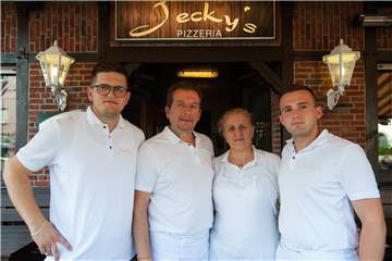 Jeckys Pizzeria ist ein echter Familienbetrieb: Das Ehepaar Xhevdet (2.v.l.) und Zurafete (2.v.r) Gjokaj, ihr Sohn Drilon (l.) und Neffe Alban Gjokaj (r.) stehen dort hinter der Theke.