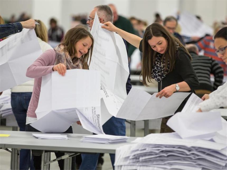 Jede Menge Papier: Wahlhelfer entfalten in Frankfurt am Main die riesigen Wahlscheine der Frankfurter Briefwähler. Foto: Frank Rumpenhorst