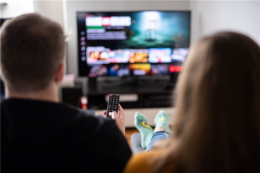 Netflix im April: Diese Serien und Filme kommen neu dazu Ein Paar sitzt vor dem Fernseher, der Mann hält die Fernbedienung.
