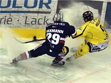 Jens Baxmann (l) von den Eisbären Berlin und Krefelds Marcel Müller kämpfen um den Puck. Foto: Maurizio Gambarini