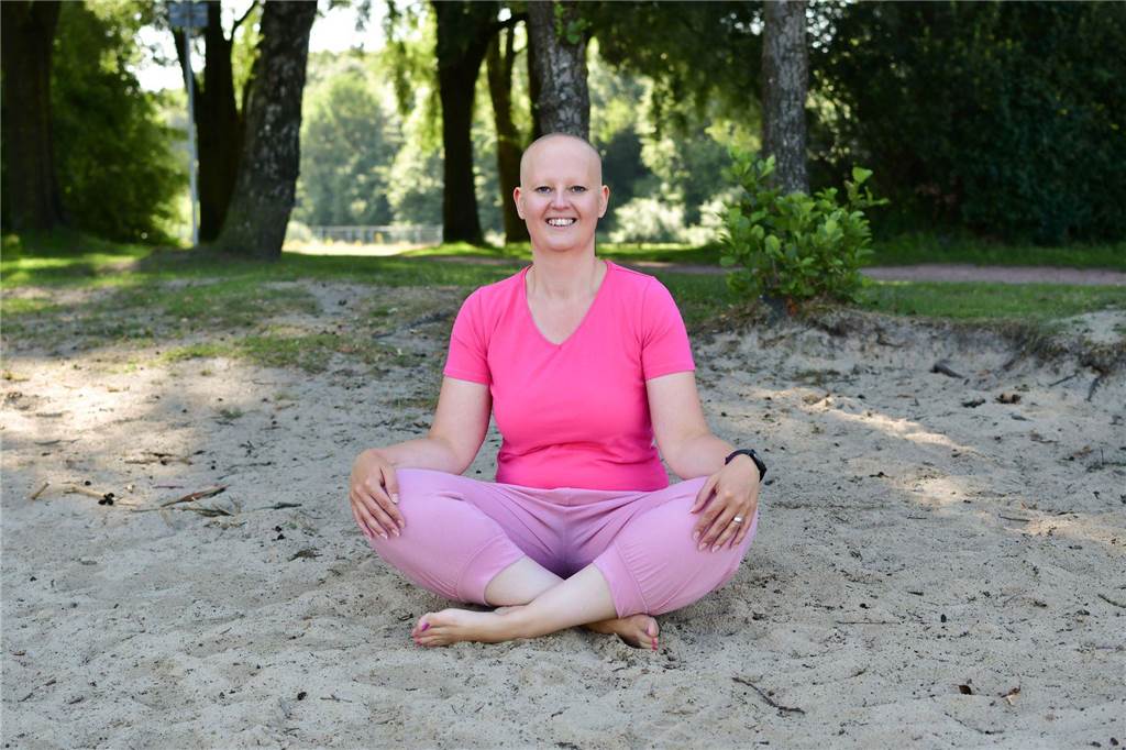 Diagnose Alopecia Universalis: Jill Klatt, die Lebensfreudeexpertin Jill Klatt meditiert im Sand.