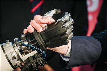 Jochen Köckler schüttelt während einer Pressekonferenz zur Hannover Messe und zur Logistik-Messe CeMat eine Roboterhand. Foto: Ole Spata