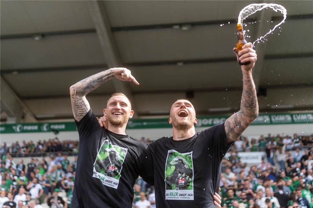 Neustart für Grodowski: Wechsel nach Bielefeld könnte perfekt passen Joel Grodowski spritzt nach dem Aufstieg von Preußen Münster in die 2. Bundesliga mit einem Bier.