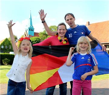 Jubelprobe im Garten der Boessingers mit Schwarz-rot-gold-blau-weiß-rot: Romy, Christiane, Fabrice und Anaïs (von links) können heute Abend nur gewinnen - allerdings ist auch ein Wermutstropfen garantiert. 
