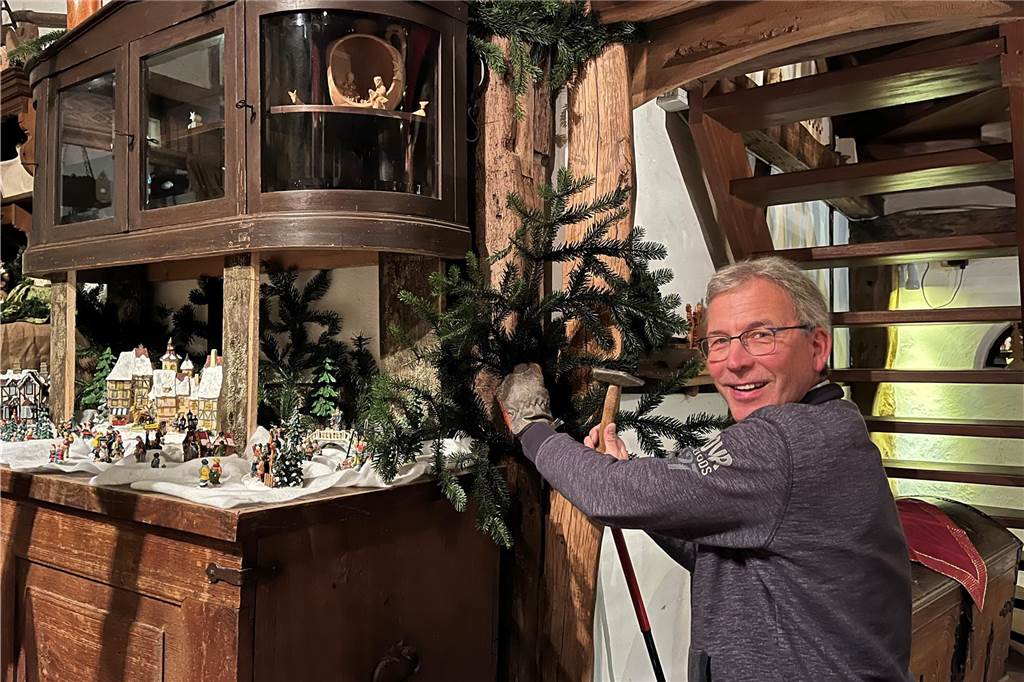 Heimatverein zeigt im Heimathaus Krippen aus Israel und dem Münsterland Jürgen Lensdorf befestigt einen Tannenzweig an einem Holzbalken.