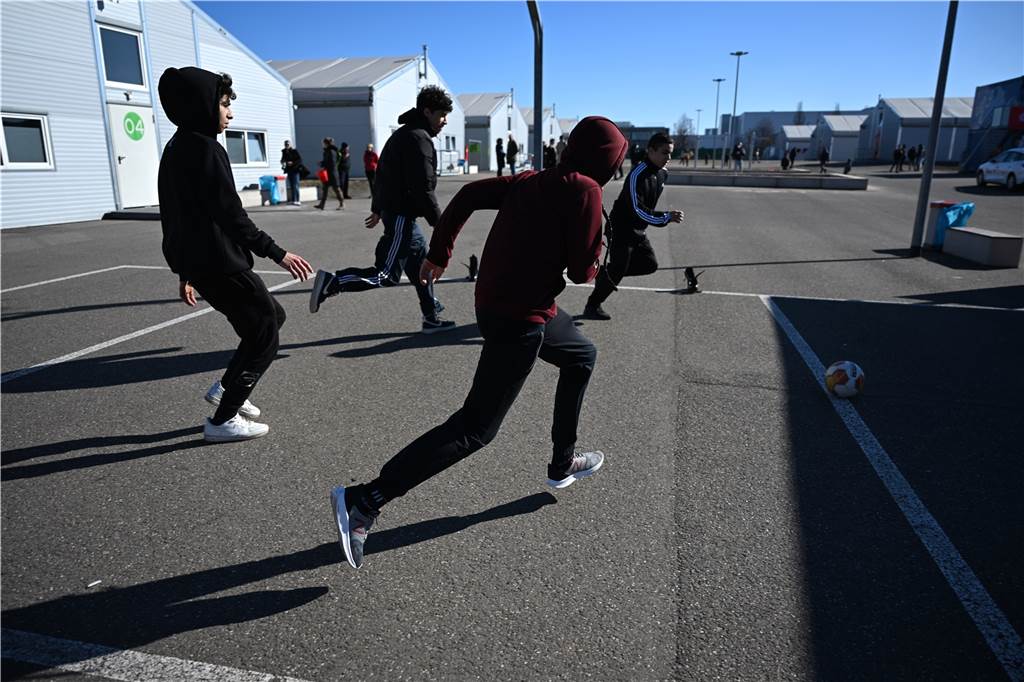 Trauer-Experten: „Die Familien haben dem Tod ins Auge geblickt“ Jugendliche spielen Fußball in der Aufnahmeeinrichtung für Geflüchtete. Beide Experten sagen: Kinder müssen spielen, um ihre Erlebnisse zu verarbeiten.