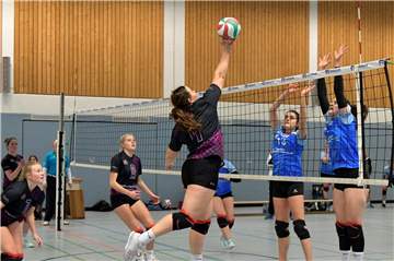 Jule Lösing (l.) und Jana Schlettert beobachten, wie Rabea Heinrich den Ball übers Netz legt.