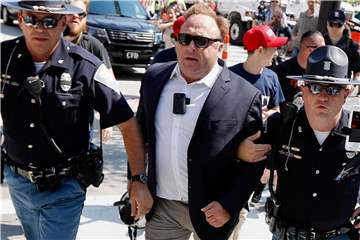 Juli 2016: Alex Jones wird von Polizisten aus einer Gruppe von Demonstranten weggeführt. Foto: John Minchillo/AP