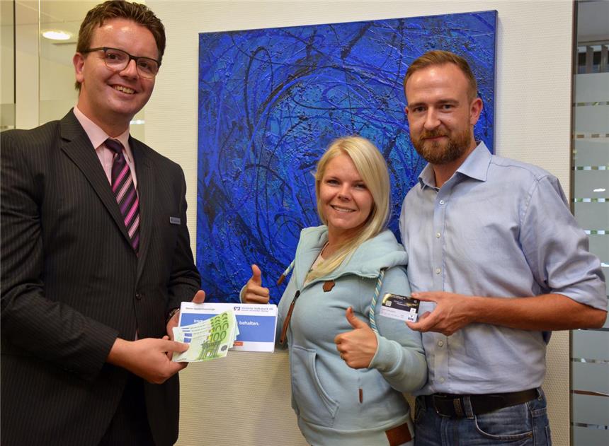 Julia und Christoph bekommen ein Sparbuch mit 500 Euro Julia und Christoph in der Volksbank. Kundenberater Klaus Niehüsener übergibt ihnen das Sparbuch.