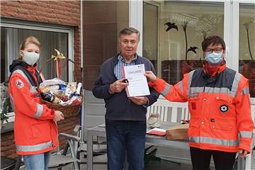 Julia und Claudia Närdemann übergeben einen Geschenkkorb für 150 Blutspenden an Josef Schlüter (73) aus Herbern.