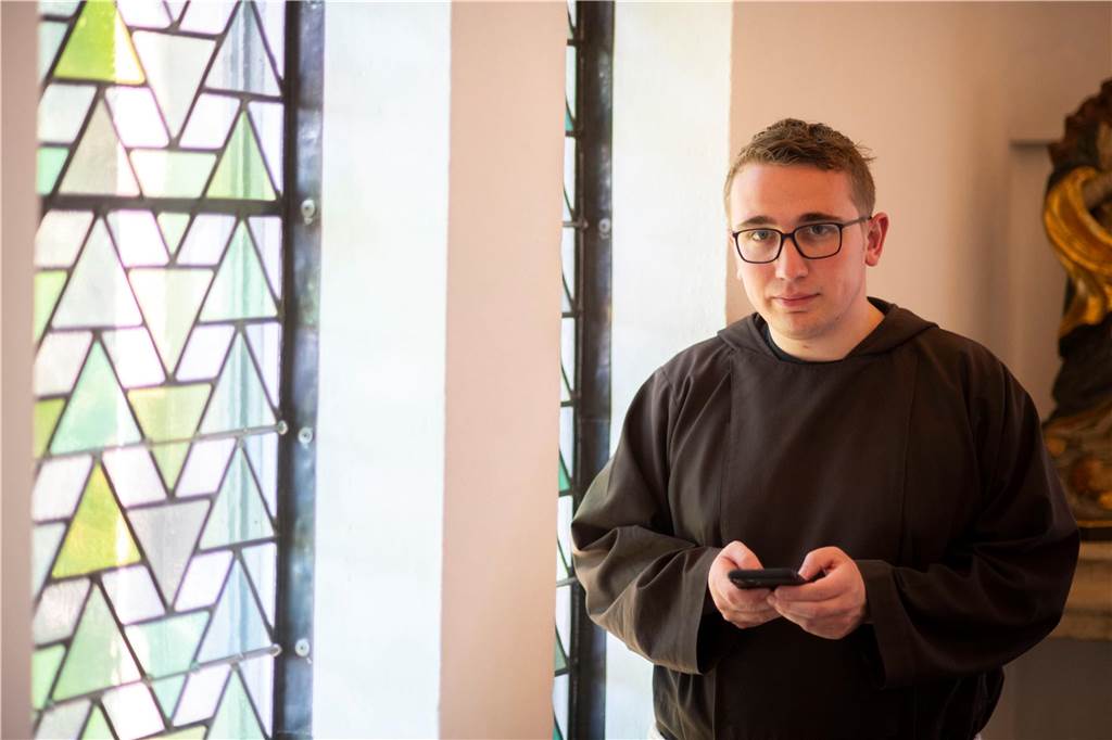 „Christfluencer“ spricht mit Papst Franziskus über Social Media Julian Kendziora in Mönchkutte mit Smartphone in der Hand