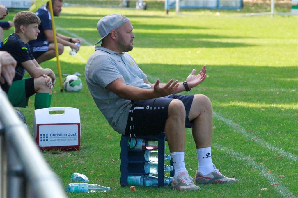 Der Umbruch hat nicht funktioniert Julian Wiedenhöft sitzt am Spielfeldrand auf einem Wasserkasten und breitet die Arme aus.