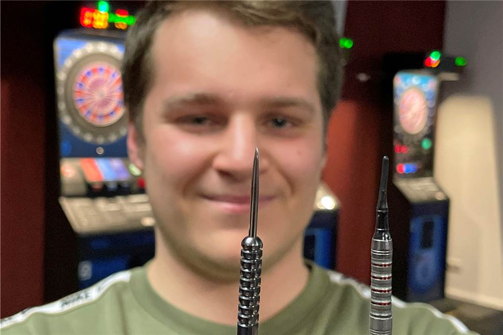1. Dartclub Werne: „Gaga“ sorgt beim Verein für Rückenwind Justin Kusemann koordiniert die Online-Aktivitäten des Vereins. Er zeigt links einen Pfeil mit Metall-Spitze für "Steel (Stahl)-Dart", rechts mit der Kunststoffspitze fürs E-Dart.