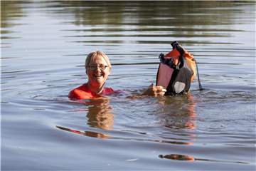 Jutta Maaßen schwimmt mit ihrer wasserdichten Fahrradtasche im Main. Foto: Frank Rumpenhorst