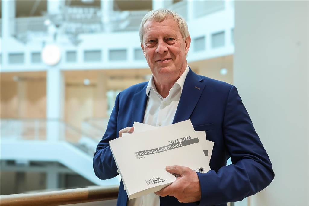 Kämmerer Jörg Stüdemann mit den Haushaltsbänden: "Wir stürzen trotz allem nicht ins Elend,