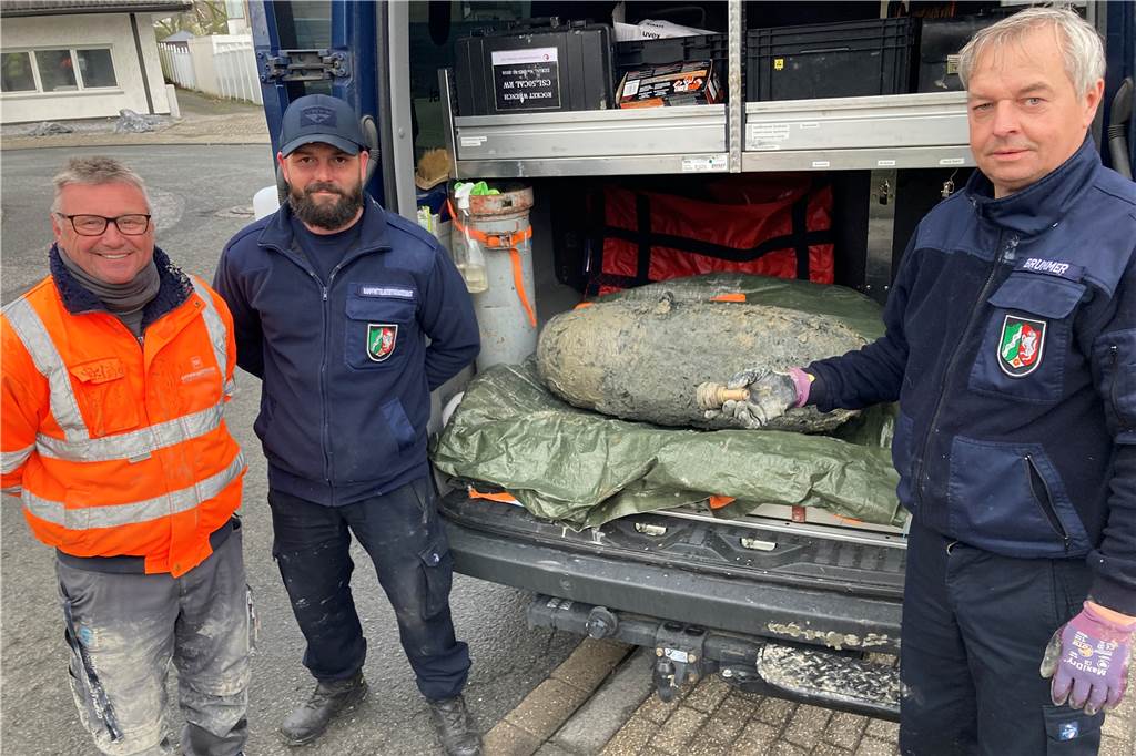Englische Fliegerbombe musste in Matsch und Wasser entschärft werden Kampfmittelräumer Andreas Brümmer (r.) mit seinem Team nach der Entschärfung mit der Bombe und dem entfernten Zünder.