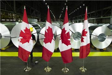 Kanadische Flaggen vor Rollen aus beschichtetem Stahl. Kanada kontert die Strafzölle der USA auf Stahl und Aluminium mit Gegenmaßnahmen. Foto: Peter Power/The Canadian Press
