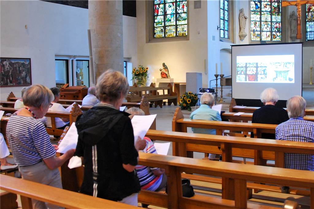 Kulturkampf in Werne: „Bismarck hat sich am Weihwasser die Finger verbrannt“ Menschen verfolgen einen Lichtbildvortrag in der Kirche St. Christophorus.