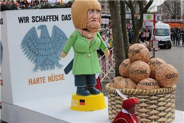 Karnevalisten ziehen am Rosenmontag mit einem Motivwagen durch Köln. Foto: Oliver Berg/Archiv