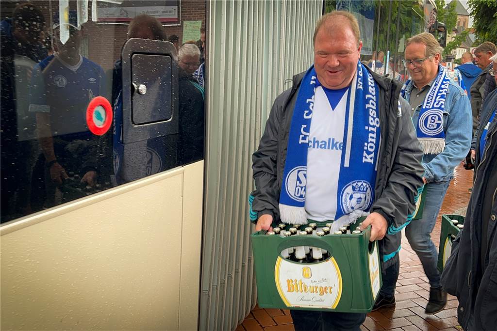 25 Jahre Königsblaue Schermbecker: S04-Fans leben besonderes Siegesritual Karsten Janz, Vorsitzender der Königsblauen Schermbecker, trägt eine der zwölf Bierkisten in den Bus, der die Gruppe zur Veltins-Arena bringt.