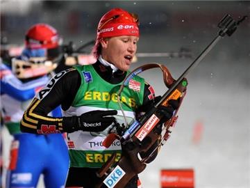 Kati Wilhelm begutachtet nach dem Schießen im Biathlon-Weltcup im Skistadion in Oberhof ihre Waffe.