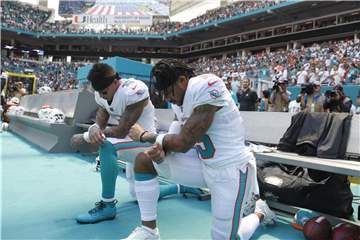 Kenny Stills (l) und Albert Wilson von den Miami Dolphins knien während der Nationalhymne. Foto: Wilfredo Lee