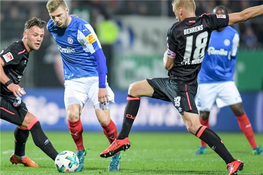Nürnberg gewinnt Aufstiegs-Duell bei Rivale Holstein Kiel Kiels Alexander Mühling (M) versucht die beiden Nürnberger Hanno Behrens (r) und Eduard Löwen stehen zu lassen. Foto: Axel Heimken