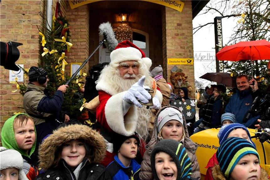 Weihnachtsmann und Christkind öffnen ihre Postfilialen Kinder begrüßen den Weihnachtsmann bei der Eröffnung des Weihnachtspostamtes im brandenburgischen Himmelpfort. Foto: Bernd Settnik/Archiv