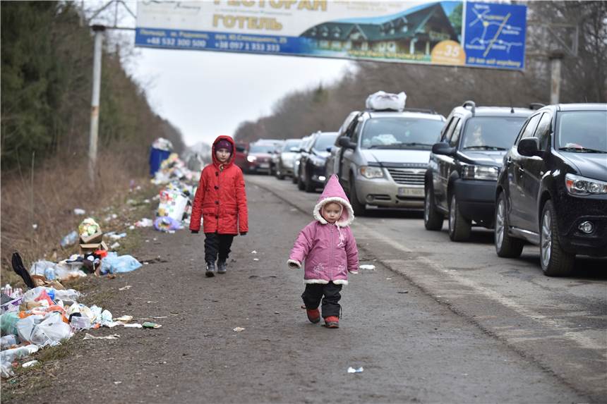 Paten für Geflüchtete gesucht: „Wir fragen auch gezielt nach Familien“ Kinder gehen an einer Autoschlange vorbei, die auf dem Weg zur polnischen Grenze ist. Auch in Schwerte werden bald mehr Flüchtlinge aus der Ukraine eintreffen. Der Arbeitskreis Asyl sucht deshalb nach Paten. Besonders Familien können helfen.