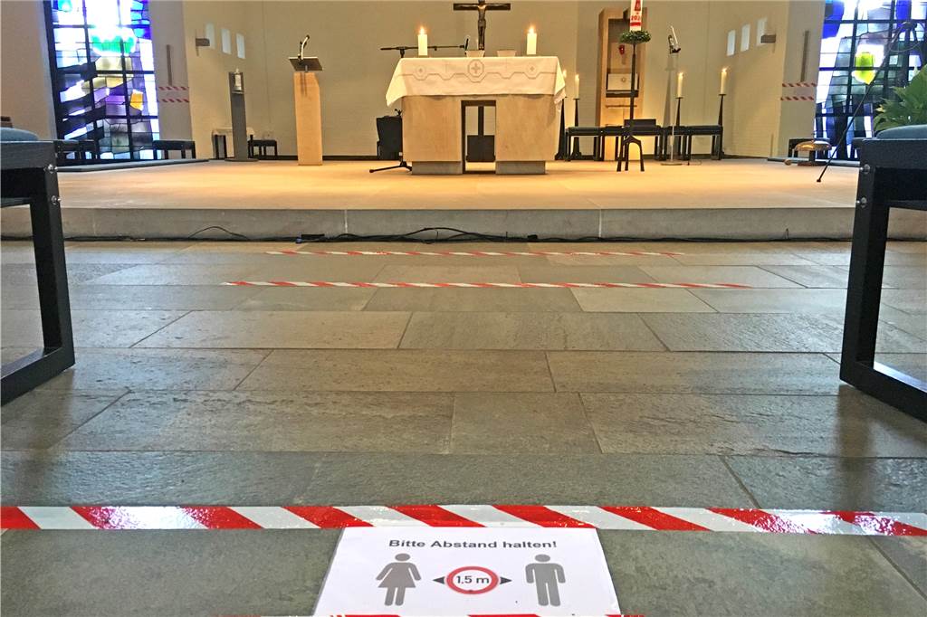 Klebestreifen auf dem Boden sorgen für Abstand unter den Gottesdienstbesuchern.