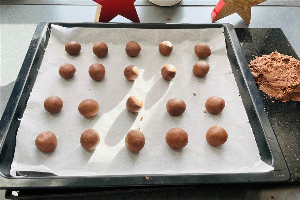 So gelingen die festlichen Schokoflocken-Plätzchen Kleine Kugeln aus dem Teig formen und auf ein Backblech legen.