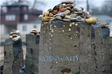 Kleine Steine liegen im ehemaligen Konzentrationslager Buchenwald auf einem Gedenkstein. Foto: Martin Schutt