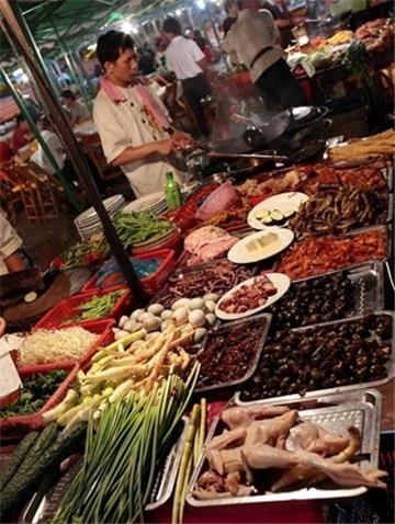 Köche an einer traditionellen Garküche auf einem Markt im chinesischen Guilin.