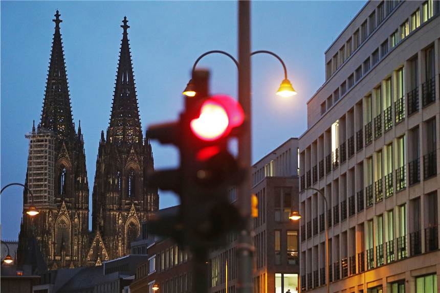Viele Corona-Ansteckungen - Köln überschreitet Warnstufe Köln: Eine Ampel steht am Dom (l) auf Rot. (Symbolbild)