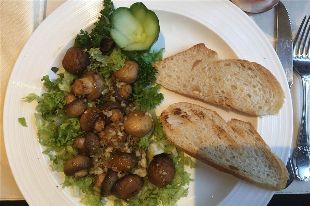 Auch ein Steakhaus kann vegetarisch sein Köstliche Vorspeise: frische Champignons mit Knoblauch und geröstetem Brot.