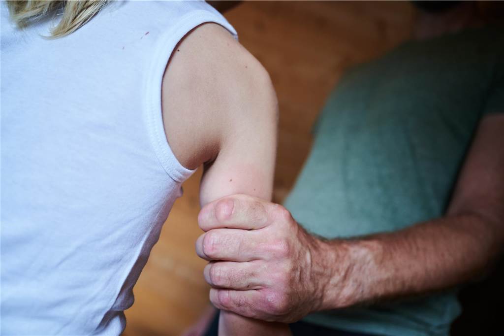 Frühe Hilfe in Ahaus: Jugendamts-Leiterin nennt Umgang „stiefmütterlich“ Ein Mann hält ein Kind am Arm fest. Es ist ein gestelltes Symbolbild