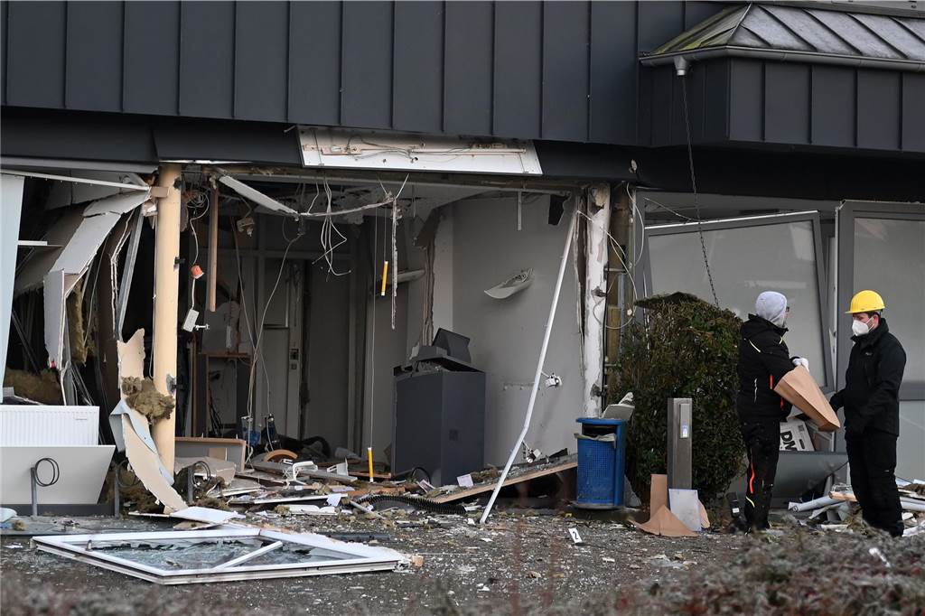 Zwei heftige Explosionen schrecken Anwohner auf: Geldautomat gesprengt Polizisten stehen vor der Volksbankfiliale an der Straße "Kerkerfeld" in Schermbeck.
