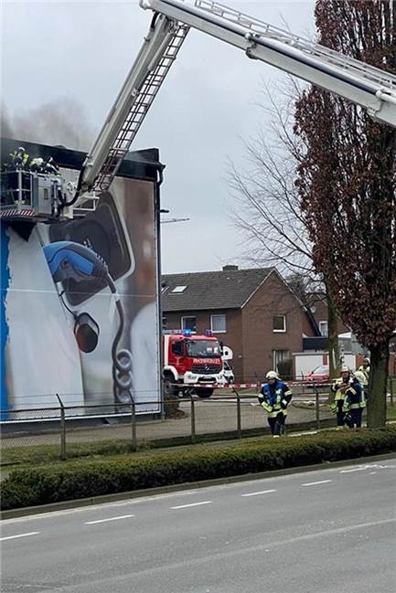 Dunkler Rauch über Firmengebäude: Vredener Discounter muss wegen Brand schließen Feuerwehrleute beim Einsatz beim Feuer an der Gutenbergstraße in Vreden