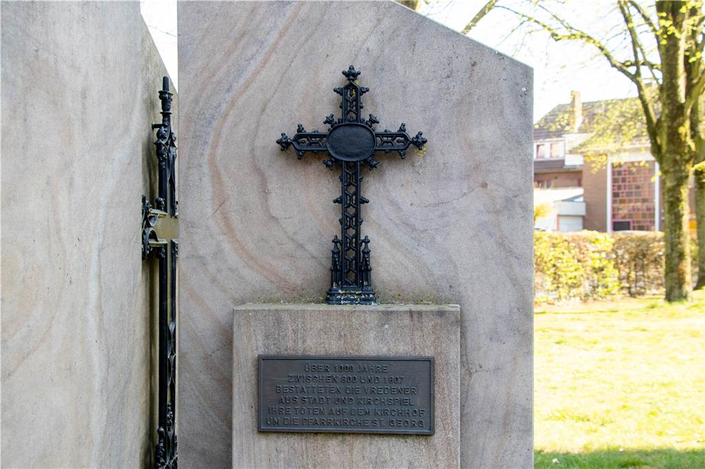 Versteckte Botschaft und ein Loch: Geheimnisse der Vredener Pfarrkirche Kreuz und Bronzetafel erinnern an den ehemaligen Friedhof an der St.-Georgs-Kirche.