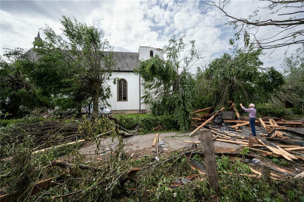 Tornados in NRW: Luftbilder zeigen Ausmaß der Zerstörung - „Ich habe Menschen weinen sehen“ Küster Paul Dirkwinkel fotografiert die katholische Kirche St. Clemens im Ortsteil Hellinghausen in Lippstadt mit seinem Handy.