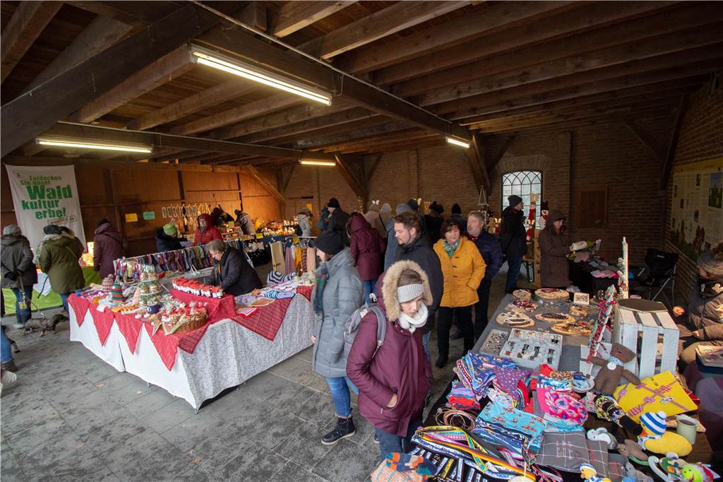 Einzigartiger Weihnachtsmarkt: Heidhof lädt zu „Wild & Weihnacht“ Blick in eine Scheune voller Kunsthandwerk und Besucher