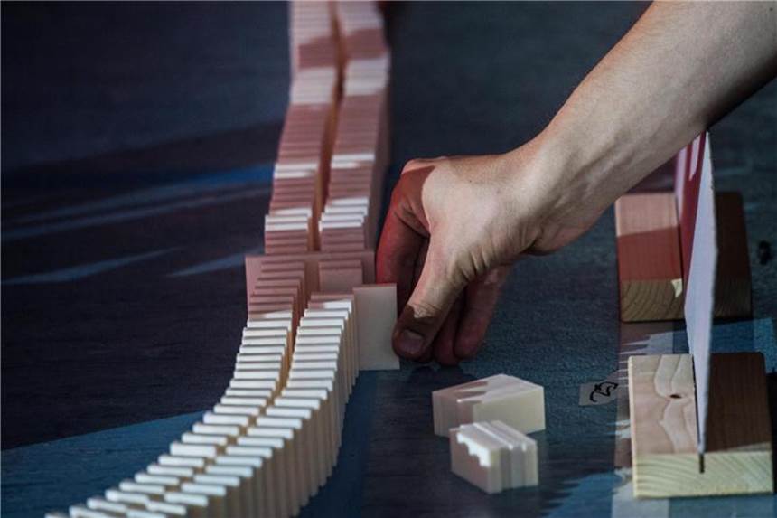 Kettenreaktion: Domino-Fans holen Weltrekorde Kurz vor dem Start werden die letzten Sicherungssperren aus den Reihen mit Dominosteinen entnommen. Foto: Andreas Arnold