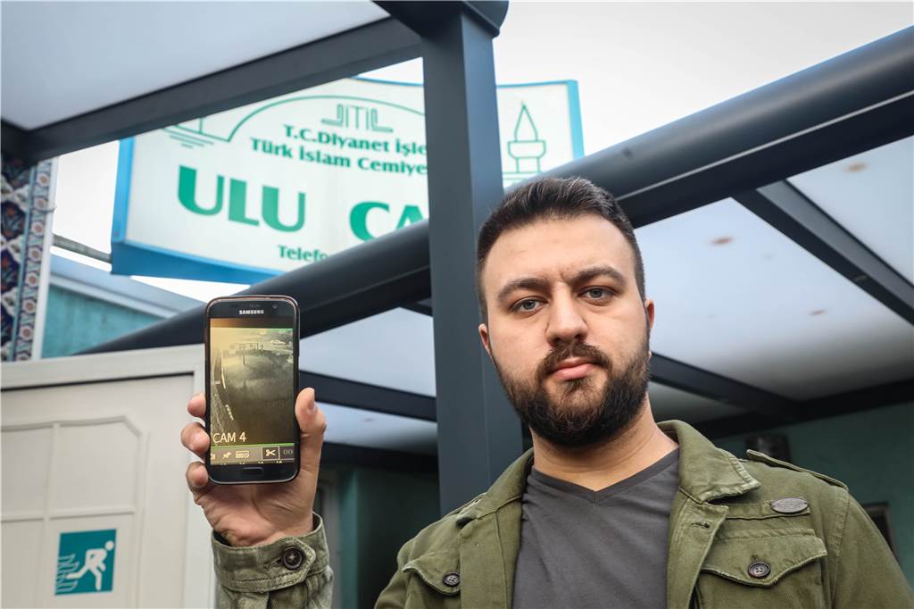 Brandanschlag auf Moschee: Bilder aus Überwachungskamera zeigen die Tat L. Cosan zeigt die Bilder aus der Überwachungskamera auf dem Handy.