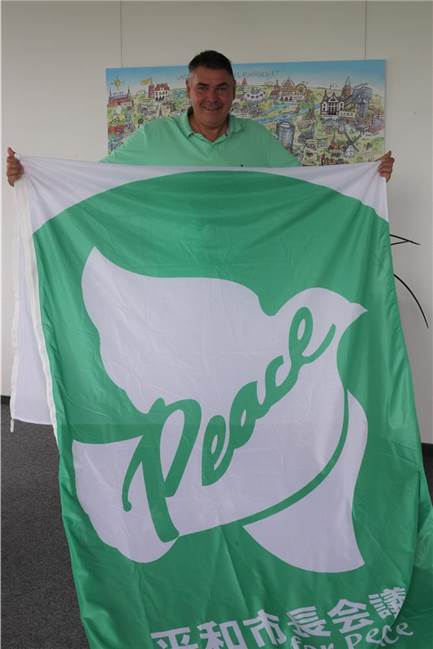 Israel-Bann: Löhr könnte mit einer besseren Flagge Haltung zeigen Landrat Mario Löhr mit der Flagge „Mayors for Peace“.
