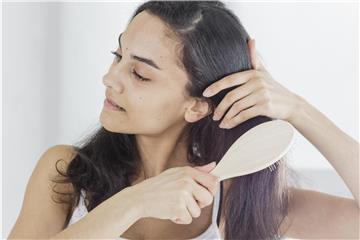 Lange Haare zu entwirren, ist nicht immer einfach - am besten arbeitet man sich von unten nach oben zum Haaransatz hoch. Foto: Monique Wüstenhagen