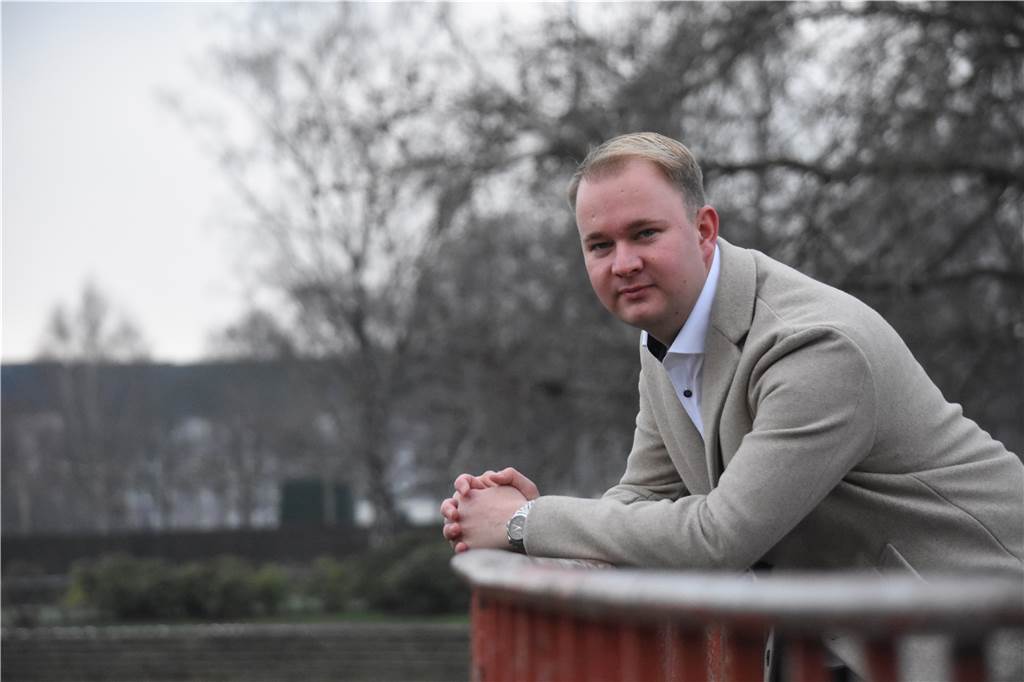 Agentur von Spielerberater Lars Rohwer ist auf 41 Klienten gewachsen Lars Rohwer lächelt im grauen Mantel in die Kamera und bückt sich über ein Geländer.