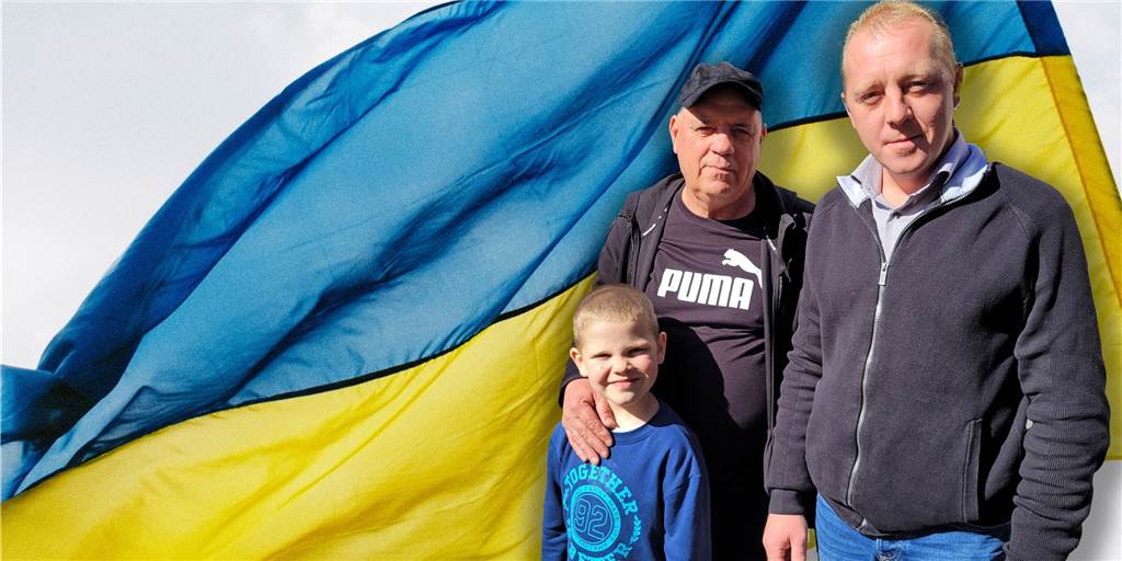 Ukrainer in Oer-Erkenschwick: „Wir haben vor der russischen Armee keine Angst“ Drei Personen vor einer ukrainischen Flagge