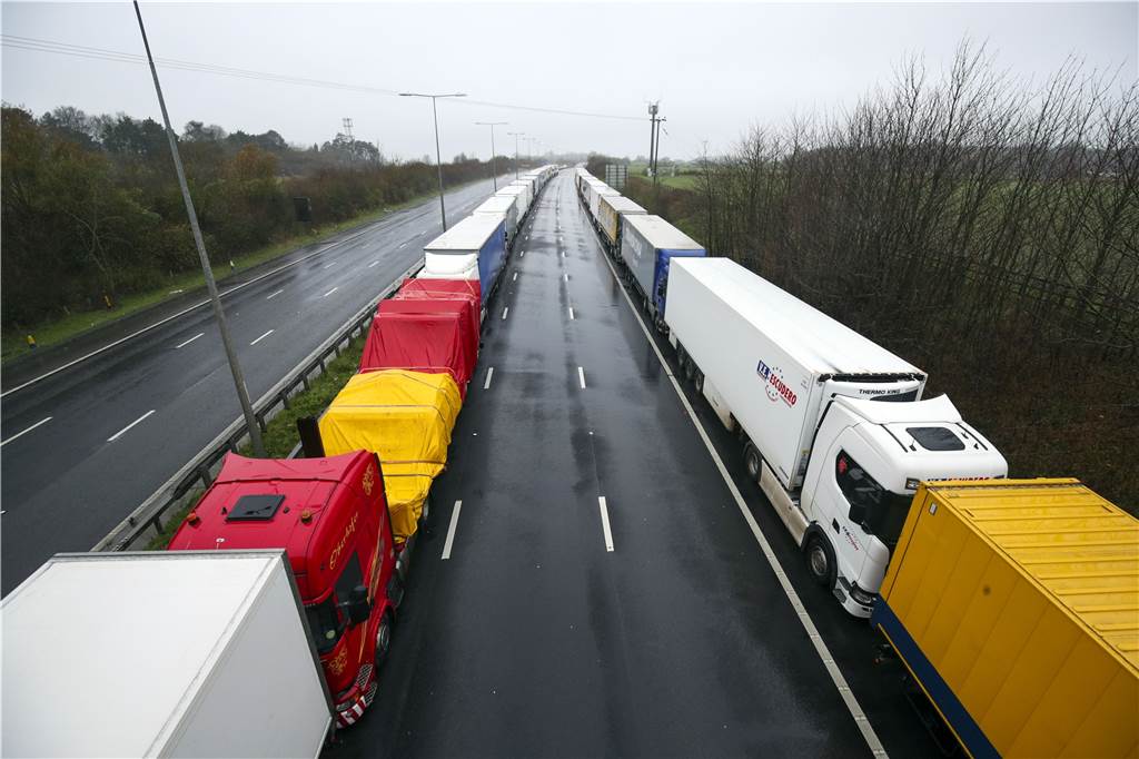 Mutiertes Coronavirus: Chaos in England - Skepsis in Europa Lastwagen stehen in langen Schlangen auf der M20 in der Nähe von Folkestone in der Grafschaft Kent im Stau. Der Zugang zum Eurotunnel wurde geschlossen. Nach Angaben des Handelsverbandes BRC überqueren in der Vorweihnachtszeit normalerweise etwa 10 000 Lastwagen täglich den Meeresarm.