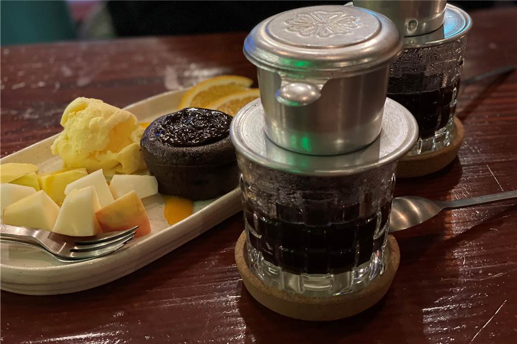Vietnamesische Gerichte und Sushi - moderne asiatische Küche Lavacake mit Vanilleeis und Mangowürfel dazu vietnamesischer Kaffee.